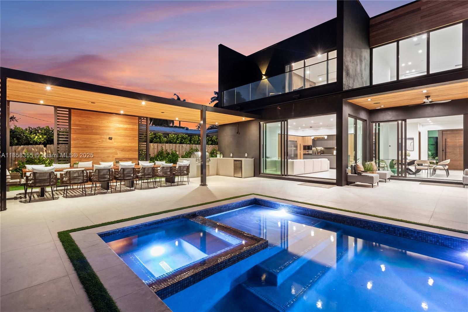 A modern two-story house features a swimming pool, outdoor dining area, and covered patio — 1960 NE 197th Ter, Miami FL 33179, MIAMI, FL