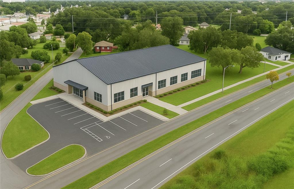 An aerial view of a modern commercial building with a metal roof and paved parking — EMMA STREET W, LAKELAND, FL