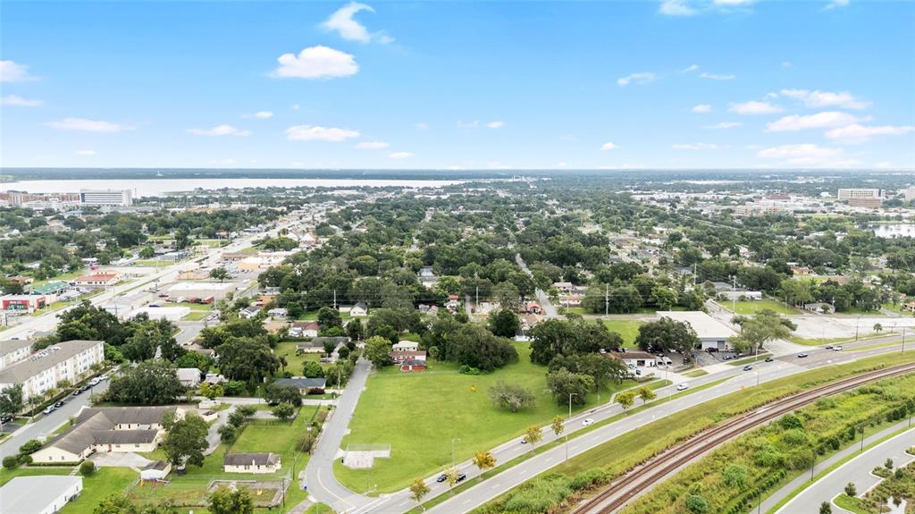 An aerial view shows a grassy vacant lot bordered by a road and railroad tracks — EMMA STREET W, LAKELAND, FL