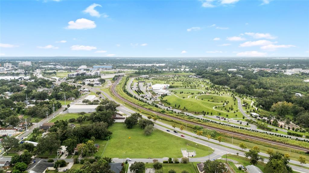 An aerial view shows a grassy lot, a railroad track, and a nearby public park — EMMA STREET W, LAKELAND, FL