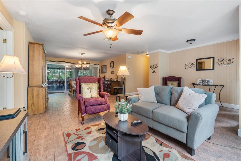 A living room with tile flooring, a ceiling fan, a sofa, and a maroon armchair — 306 GRIMES DRIVE, AUBURNDALE, FL