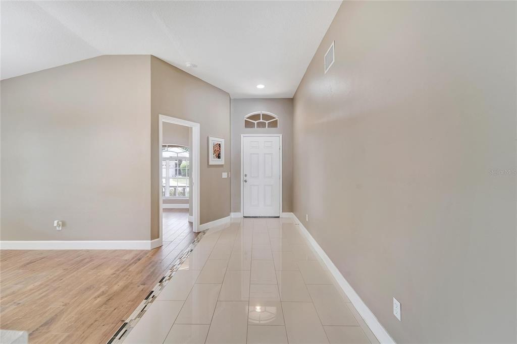 A tiled entryway leads to a white front door with a decorative arched transom window — 12739 STANDBRIDGE DRIVE, RIVERVIEW, FL