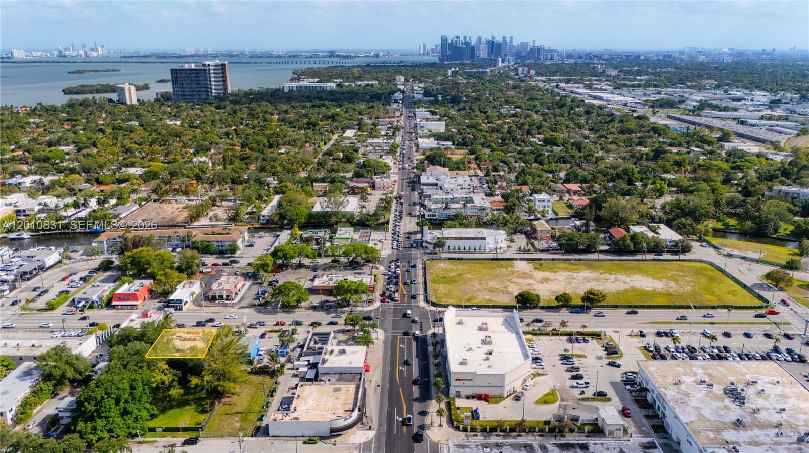 An aerial view shows a commercial area with a highlighted vacant lot and city skyline — 633 NE 79th St, Miami FL 33138, MIAMI, FL