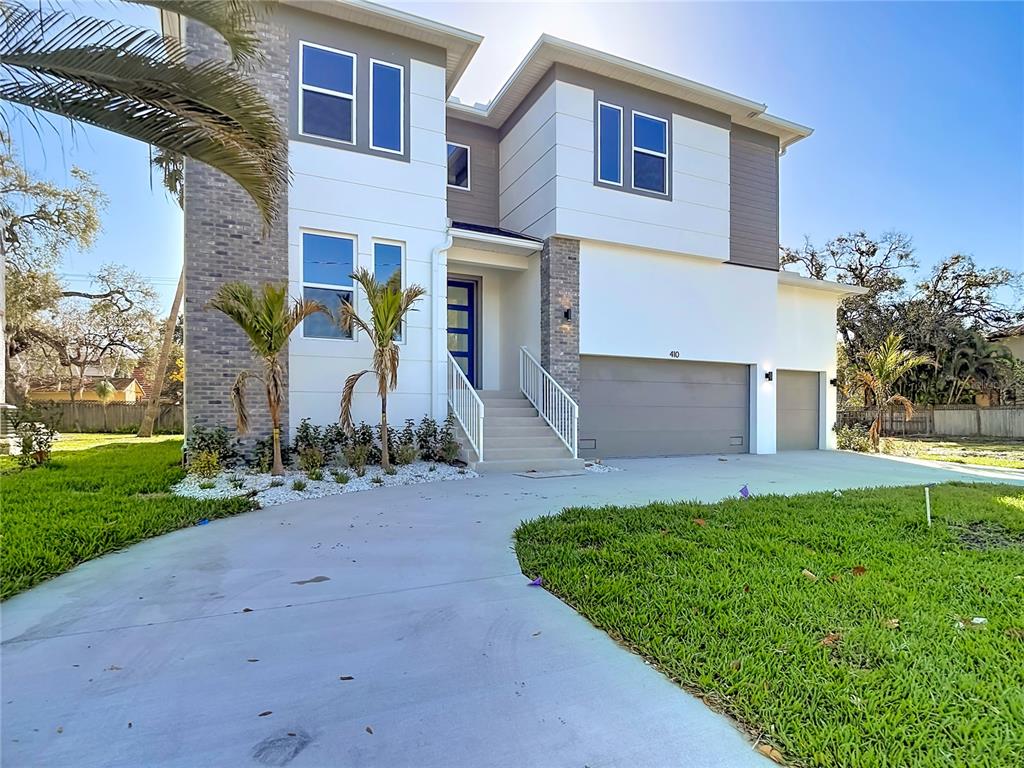 A two-story modern house with a concrete driveway, white siding, and a gray garage — 410 S WEST SHORE BOULEVARD, TAMPA, FL