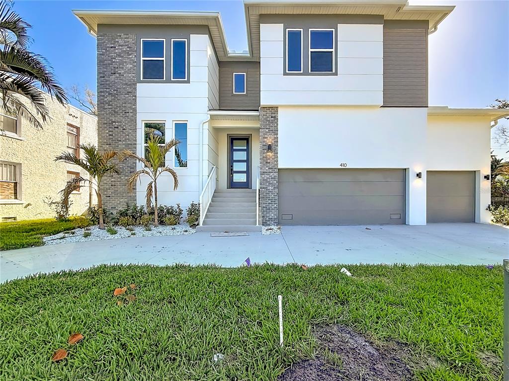 A two-story modern house features a gray stone facade, white stucco, and a three-car garage — 410 S WEST SHORE BOULEVARD, TAMPA, FL