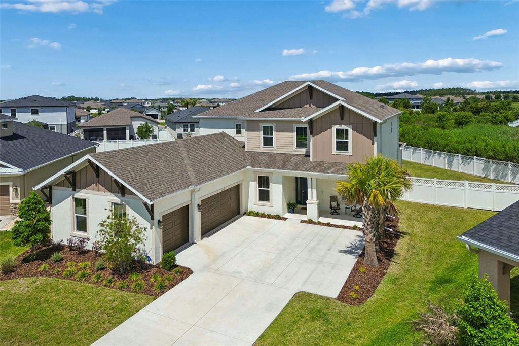 An aerial view of a two-story suburban house with a concrete driveway and palm tree — 6870 TALAMORE DRIVE, WESLEY CHAPEL, FL
