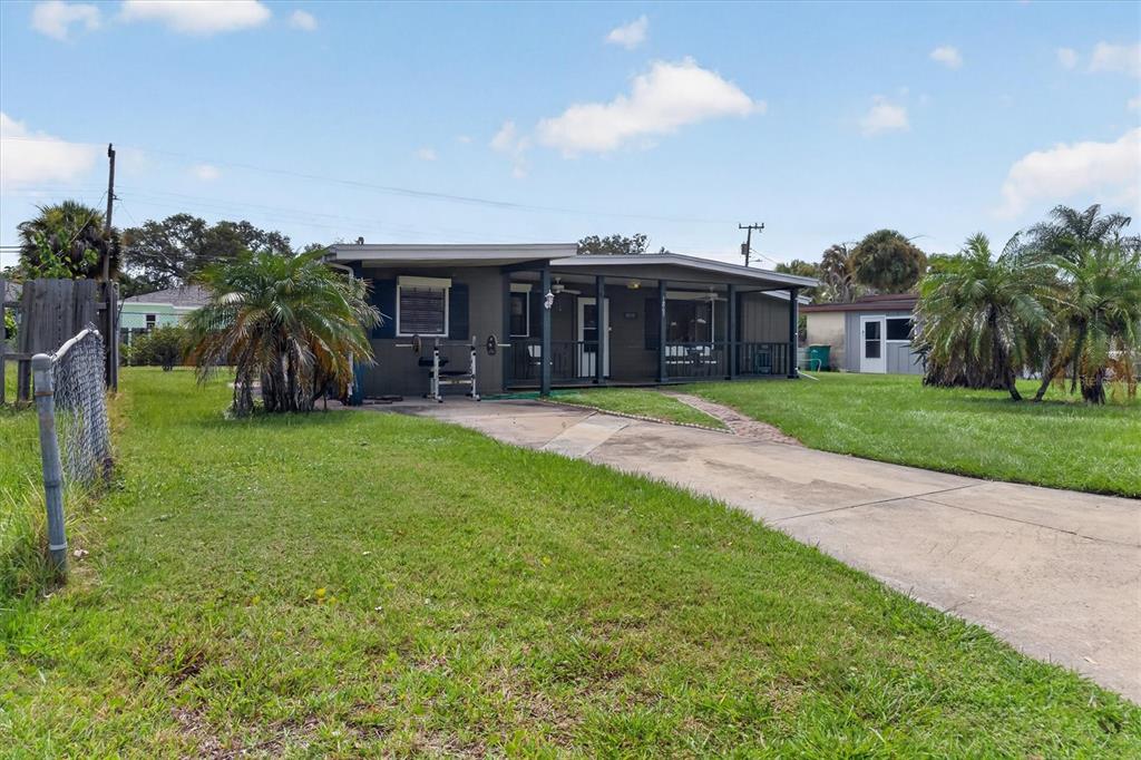 A single-story house with a covered front porch and a concrete driveway sits on grass — 1865 CEDARWOOD DRIVE, MELBOURNE, FL