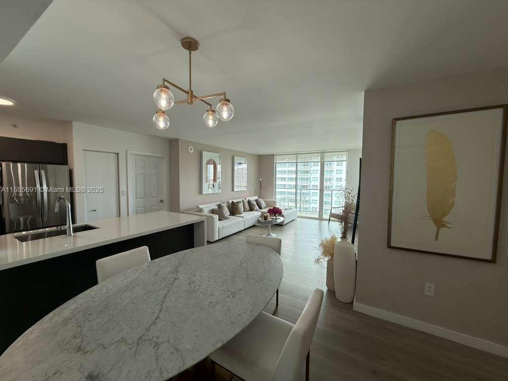An open-concept living area features a kitchen island, dining table, and a sofa set — 1155 Brickell Bay Dr # 1408, Miami FL 33131, MIAMI, FL