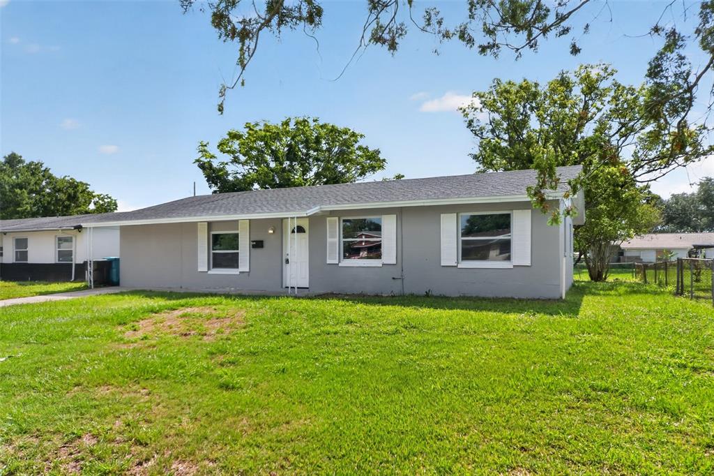 A single-story gray house with white shutters and a white front door sits on grass — 1635 RAVENALL AVENUE, ORLANDO, FL