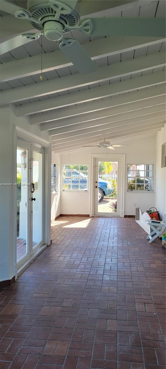 A covered patio features a brick floor, white exposed-beam ceiling, ceiling fans, and glass doors — 5200 SW 89th Pl, Miami FL 33165, MIAMI, FL