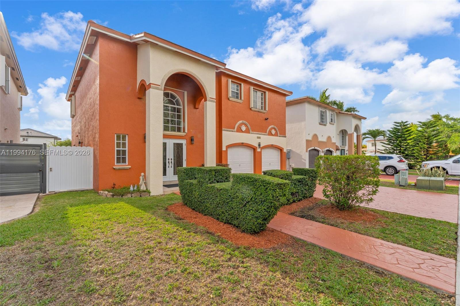 A two-story orange and beige house features a double garage and a landscaped front yard — 6502 SW 157th Ct, Miami FL 33193, MIAMI, FL