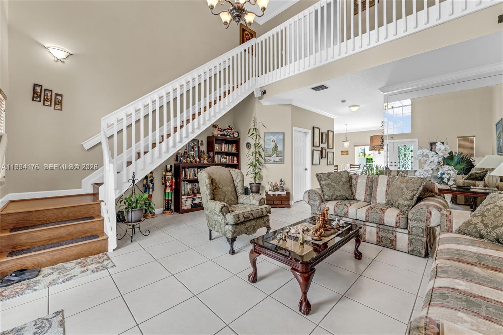 A living room features a white staircase, tiled floors, and traditional patterned furniture — 6502 SW 157th Ct, Miami FL 33193, MIAMI, FL