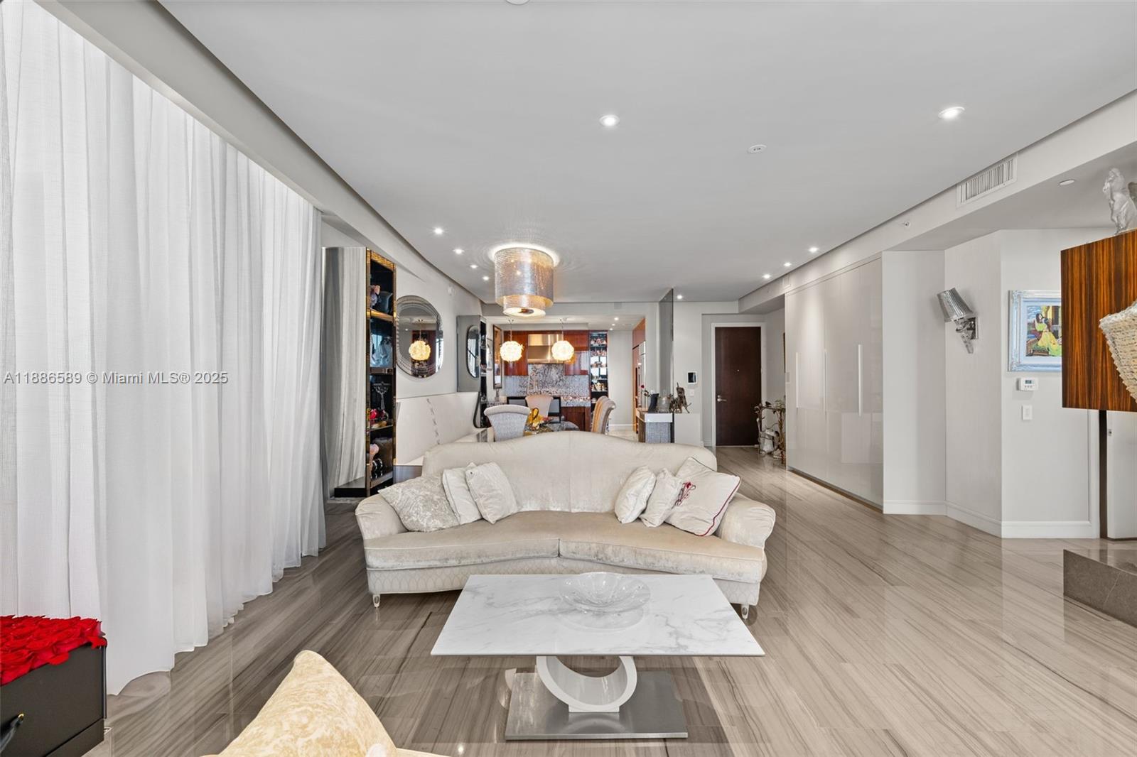 A modern living room features a curved sofa, marble coffee table, and polished tile floors — 9705 Collins Ave # 2304N, Bal Harbour FL 33154, BAL HARBOUR, FL