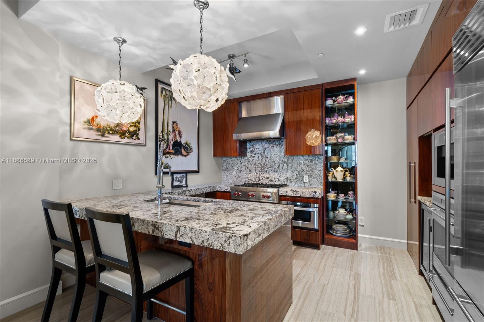 A modern kitchen features wood cabinetry, granite countertops, a center island, and two pendant lights — 9705 Collins Ave # 2304N, Bal Harbour FL 33154, BAL HARBOUR, FL