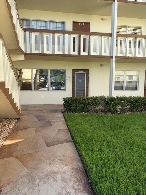 A brown door with a security screen and a window looking out onto a parking lot — 381 Mansfield J, Boca Raton FL 33434, BOCA RATON, FL