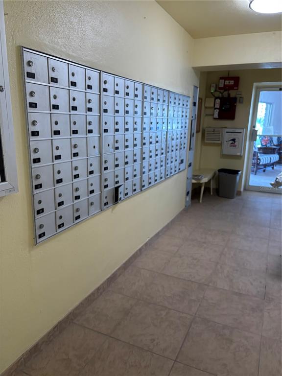 A hallway features a large wall-mounted metal mailbox unit and a tile floor — 4725 COVE CIRCLE UNIT 104, ST PETERSBURG, FL