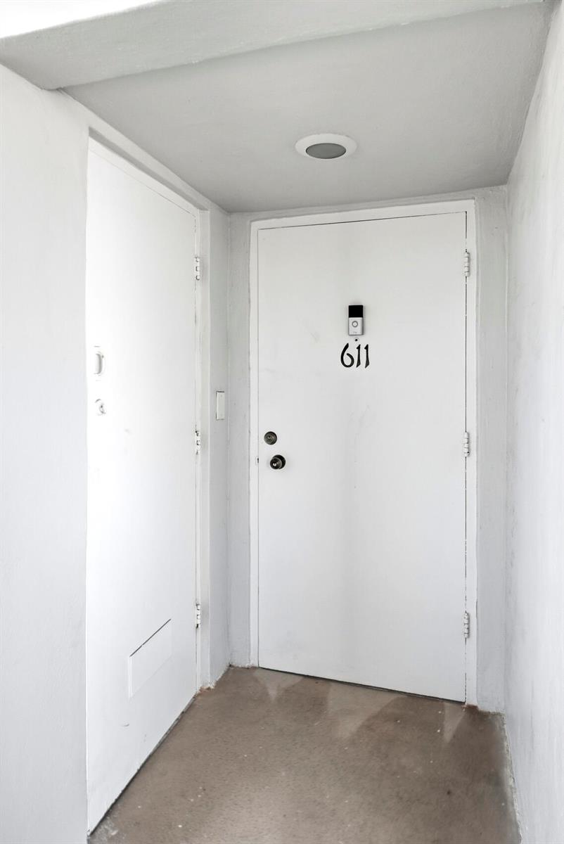 A white apartment entrance door labeled 611 with a doorbell camera and two locks — 111 N Pompano Beach Boulevard # 611, Pompano Beach FL 33062, POMPANO BEACH, FL