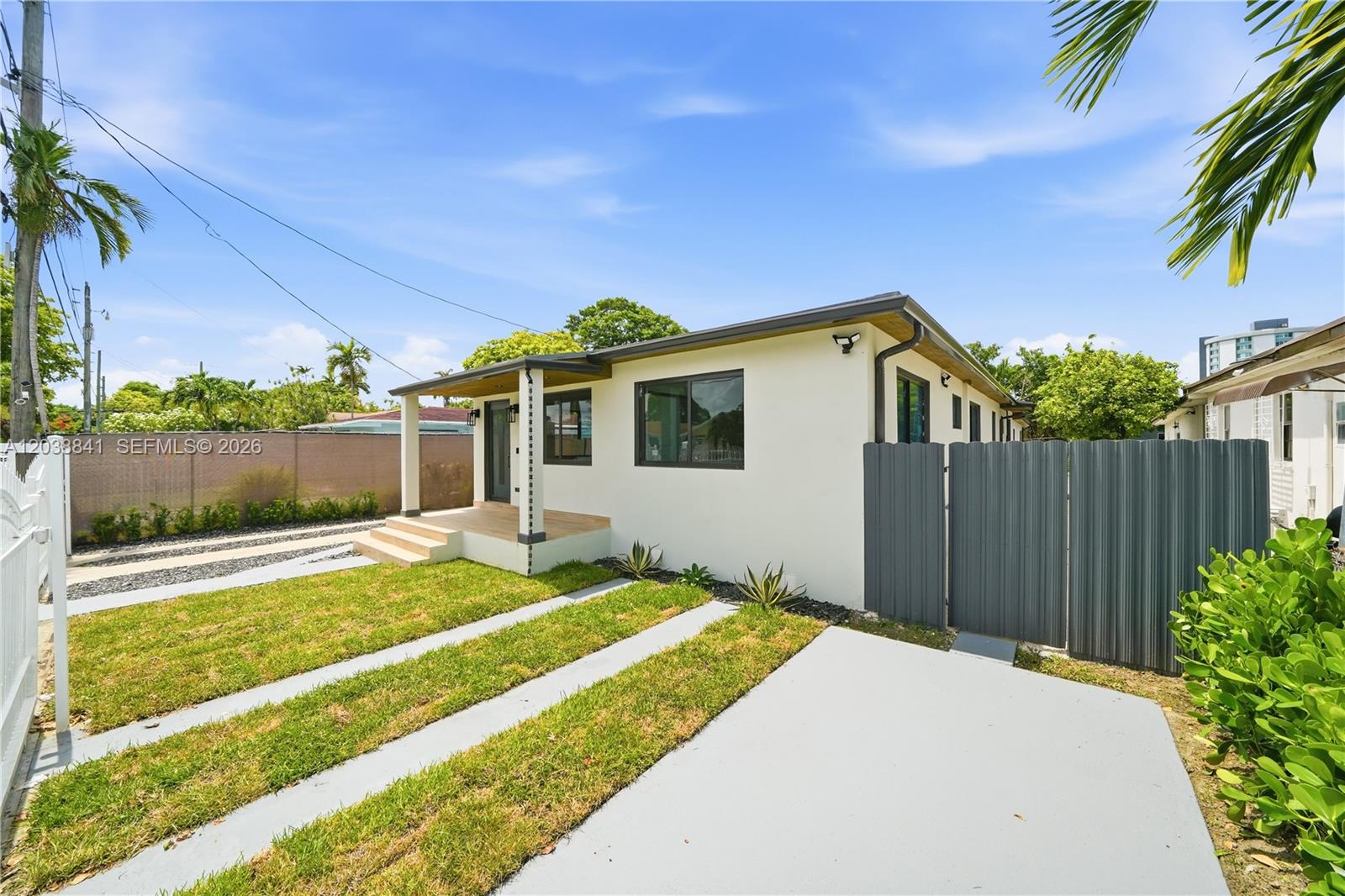 A single-story house with a white exterior, a small front porch, and a gray fence — 1861 NW 27th St # 1, Miami FL 33142, MIAMI, FL