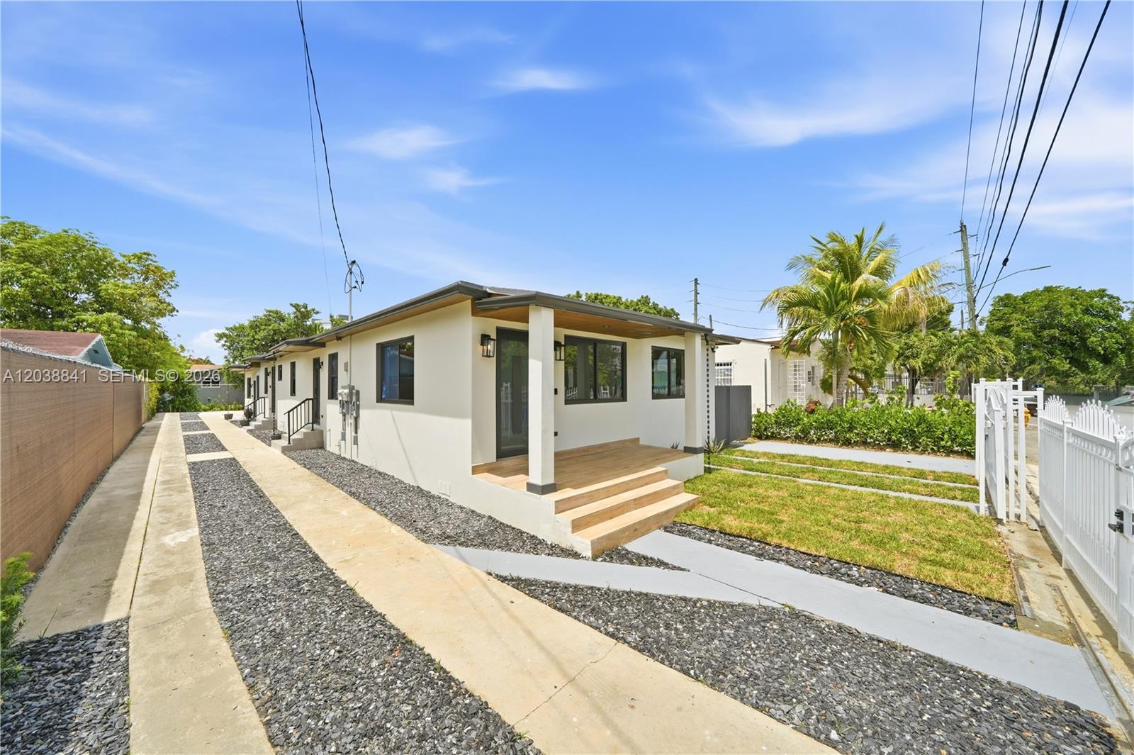 A single-story house features a covered front porch, a gravel driveway, and a fenced yard — 1861 NW 27th St # 1, Miami FL 33142, MIAMI, FL
