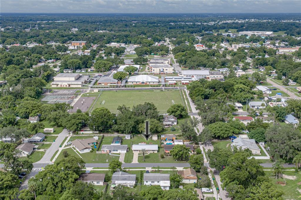 An aerial view shows a single-story house with a pool in a residential neighborhood — 5745 13TH STREET, ZEPHYRHILLS, FL
