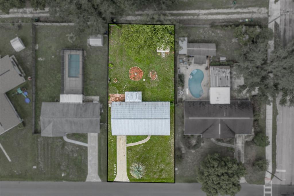 An aerial view shows a rectangular residential lot containing a house with a metal roof — 5745 13TH STREET, ZEPHYRHILLS, FL