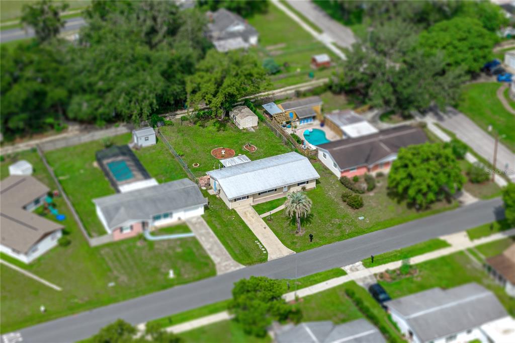An aerial view shows a single-story house with a driveway and a large backyard — 5745 13TH STREET, ZEPHYRHILLS, FL