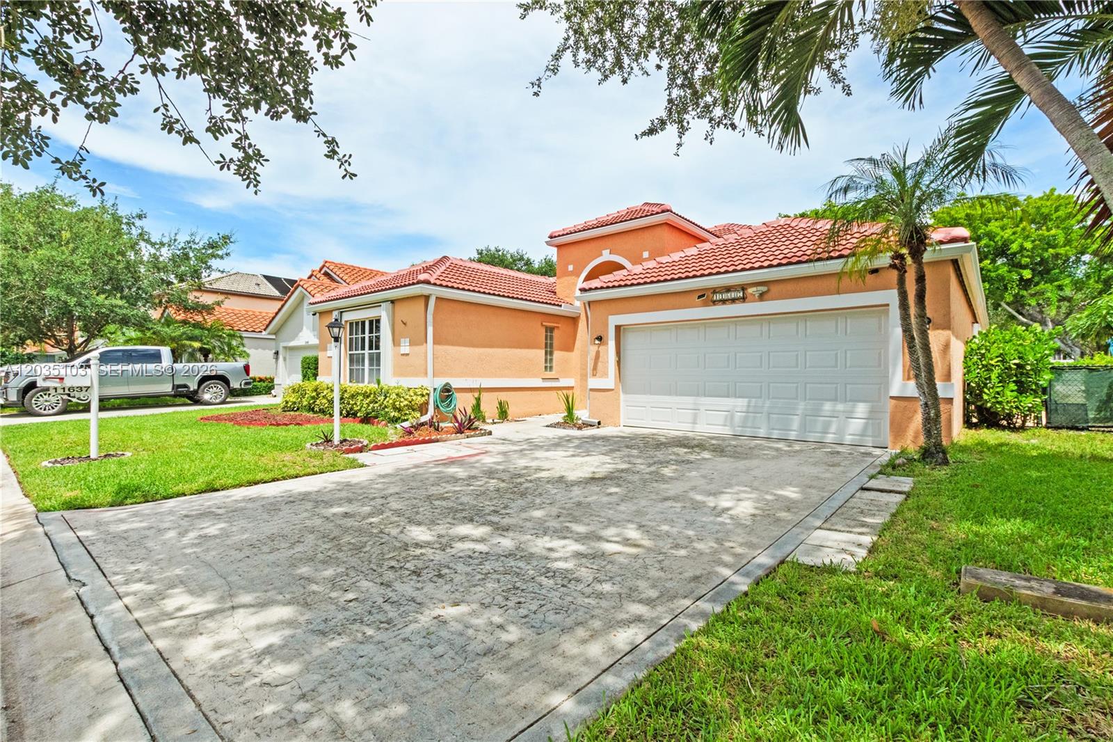 A single-story peach-colored house with a tile roof, two-car garage, and a concrete driveway — 11637 NW 3rd Dr, Coral Springs FL 33071, CORAL SPRINGS, FL