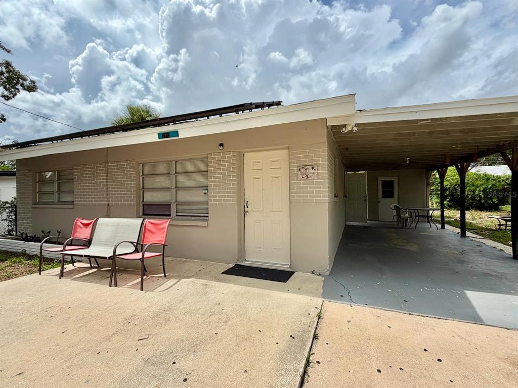 A single-story house exterior features a concrete driveway, a covered carport, and a front patio — 7215 JAMES STREET, PORT RICHEY, FL