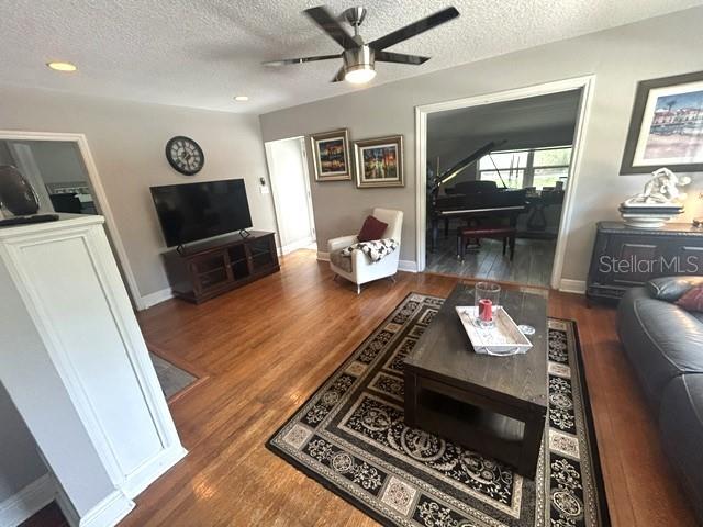 A living room features hardwood floors, a ceiling fan, a television, and a piano room — 428 ALTALOMA AVENUE, ORLANDO, FL