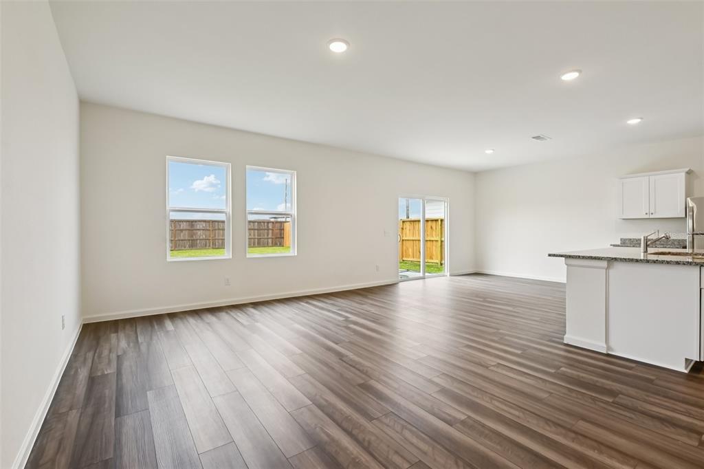 An open-concept living area features wood-look flooring, white walls, recessed lighting, and a kitchen island — 1620 NORFOLK TRAIL, DELAND, FL