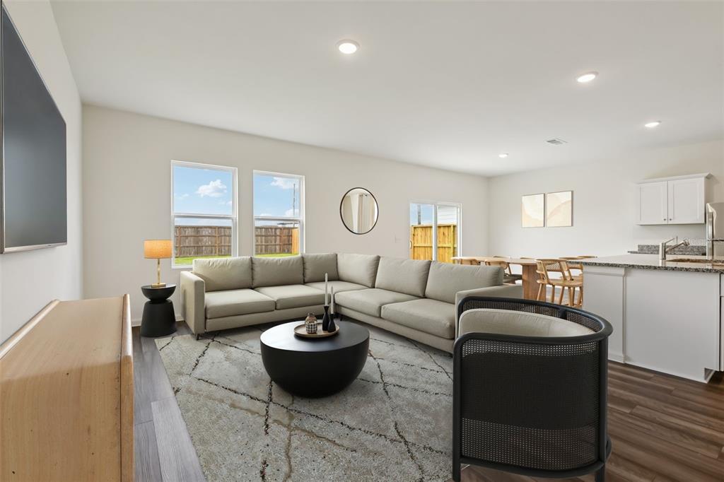 A living room with a sectional sofa, round coffee table, and open kitchen area — 1620 NORFOLK TRAIL, DELAND, FL