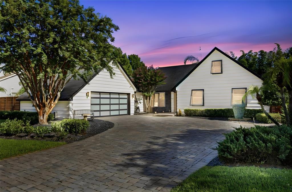 A white house with a black roof and a paved driveway at sunset — 465 MANDALAY ROAD, ORLANDO, FL