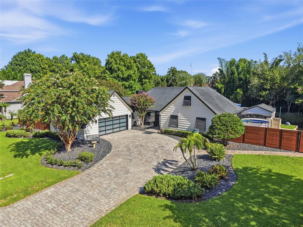 A single-story house with a paved driveway, white siding, and a large tree in front — 465 MANDALAY ROAD, ORLANDO, FL