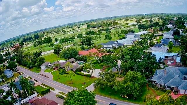 A single-story house with dark gray siding and a large tree in the front yard — 5000 9TH AVENUE W, BRADENTON, FL