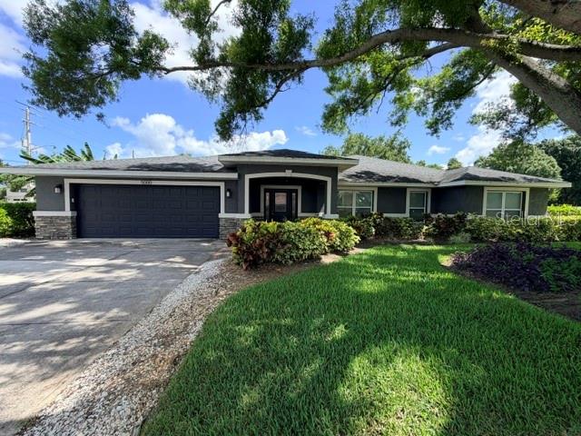 An aerial view shows a suburban neighborhood with houses, trees, and a golf course — 5000 9TH AVENUE W, BRADENTON, FL