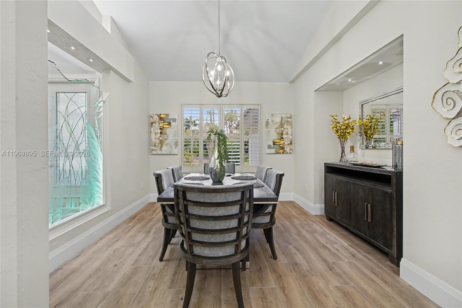 A dining room features a dark wood table, gray upholstered chairs, and wood-look flooring — 5186 Tallowood Way, Naples FL 34116, NAPLES, FL