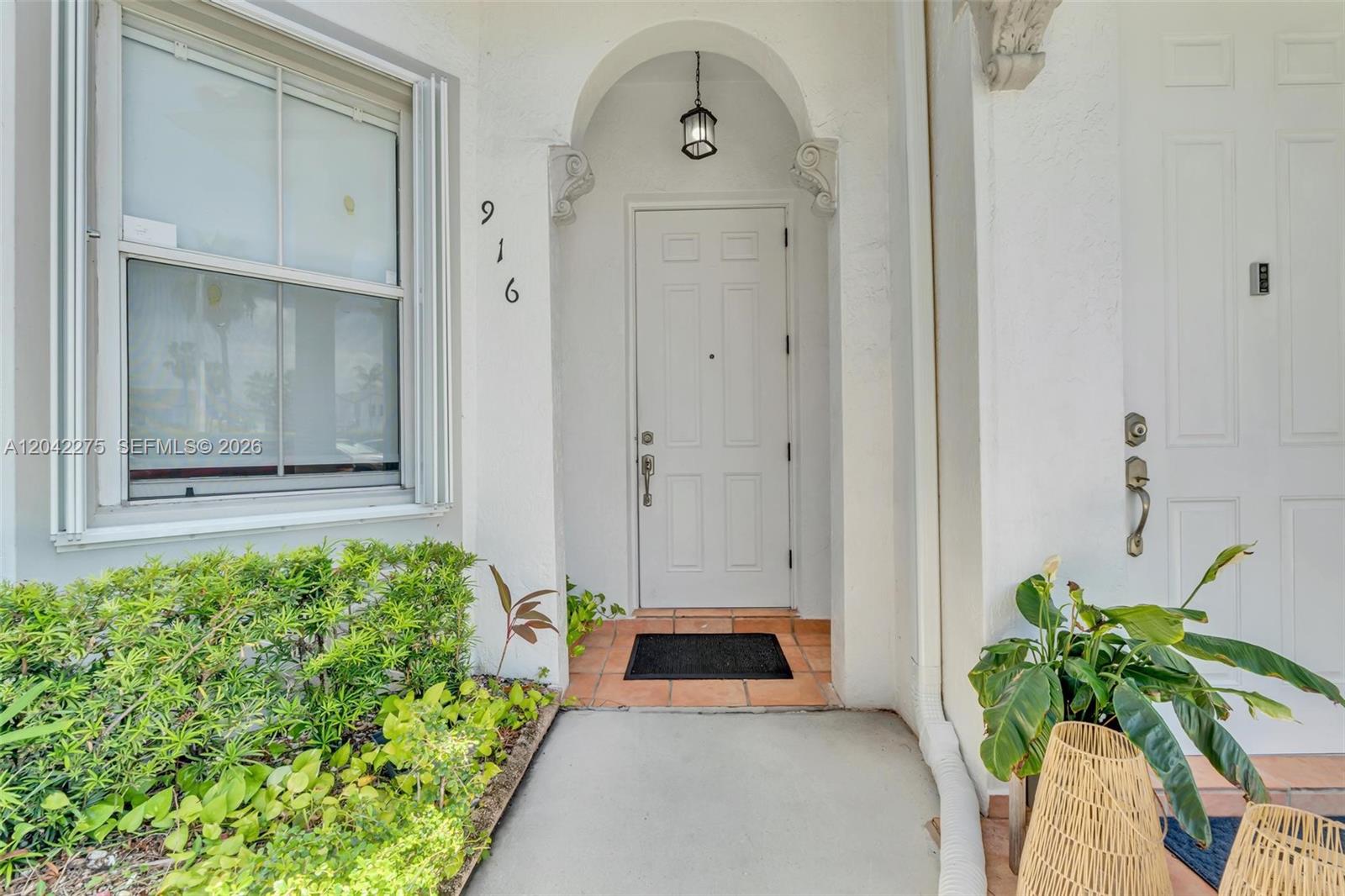 A white front door with a house number is set within an arched entryway — 5570 NW 107th Ave # 916, Doral FL 33178, DORAL, FL