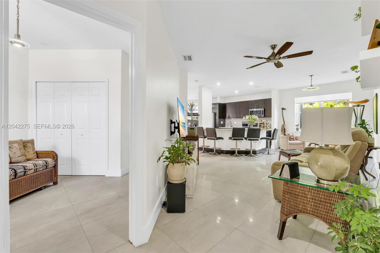 An open-concept living area features a kitchen with a breakfast bar and tile flooring — 5570 NW 107th Ave # 916, Doral FL 33178, DORAL, FL