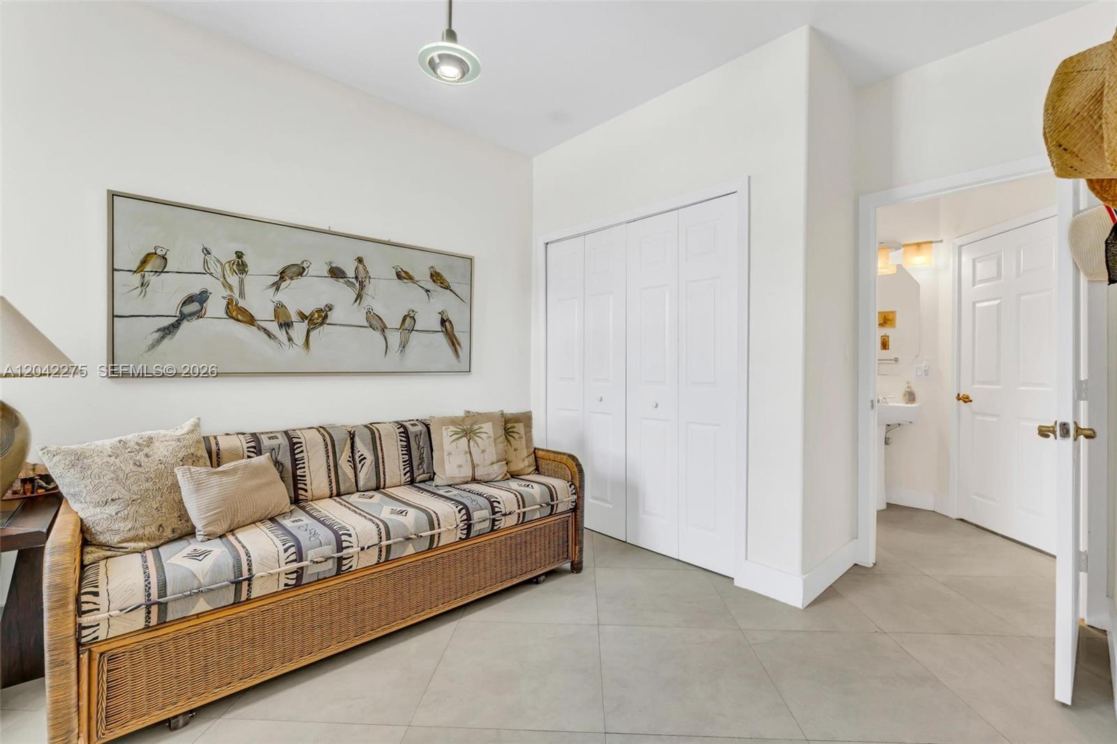 A room features a wicker daybed, a bird-themed wall painting, and a white closet — 5570 NW 107th Ave # 916, Doral FL 33178, DORAL, FL