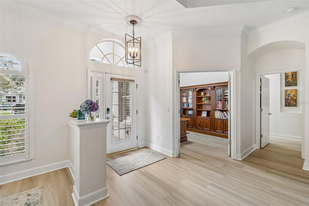 A bright entryway features light wood flooring, a decorative pendant light, and a home office — 3825 MISTY LANDING DRIVE, VALRICO, FL