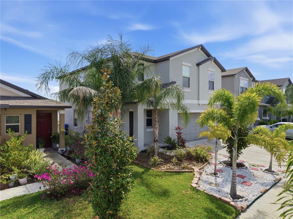 A two-story suburban house with a gray exterior, a garage, and palm trees in front — 861 OLIVE CONCH STREET, RUSKIN, FL
