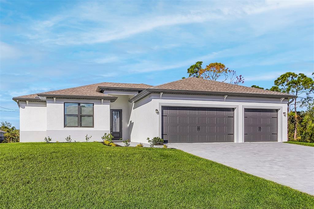 A single-story house with a white stucco exterior, a gray three-car garage, and a lawn — 4570 GILLOT BOULEVARD, PORT CHARLOTTE, FL