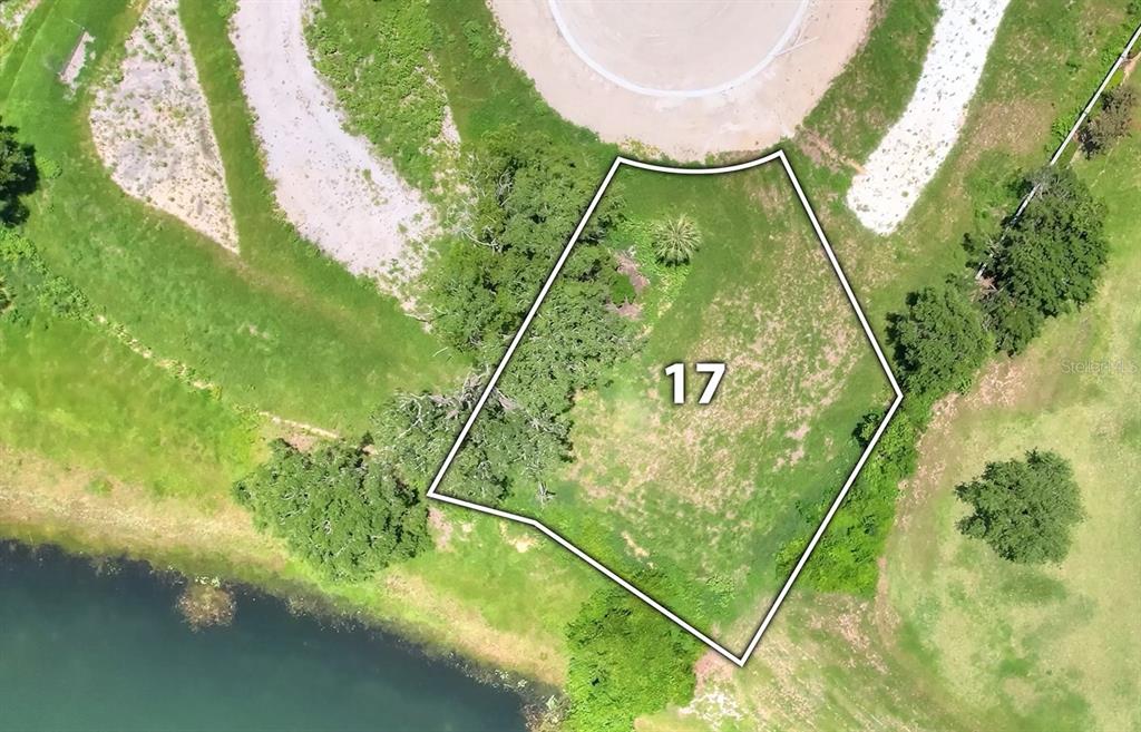 An aerial view shows a vacant, irregularly shaped residential lot marked with the number 17 — 129 TRANQUIL MIRROR LAKE COURT Lot 17, CLERMONT, FL