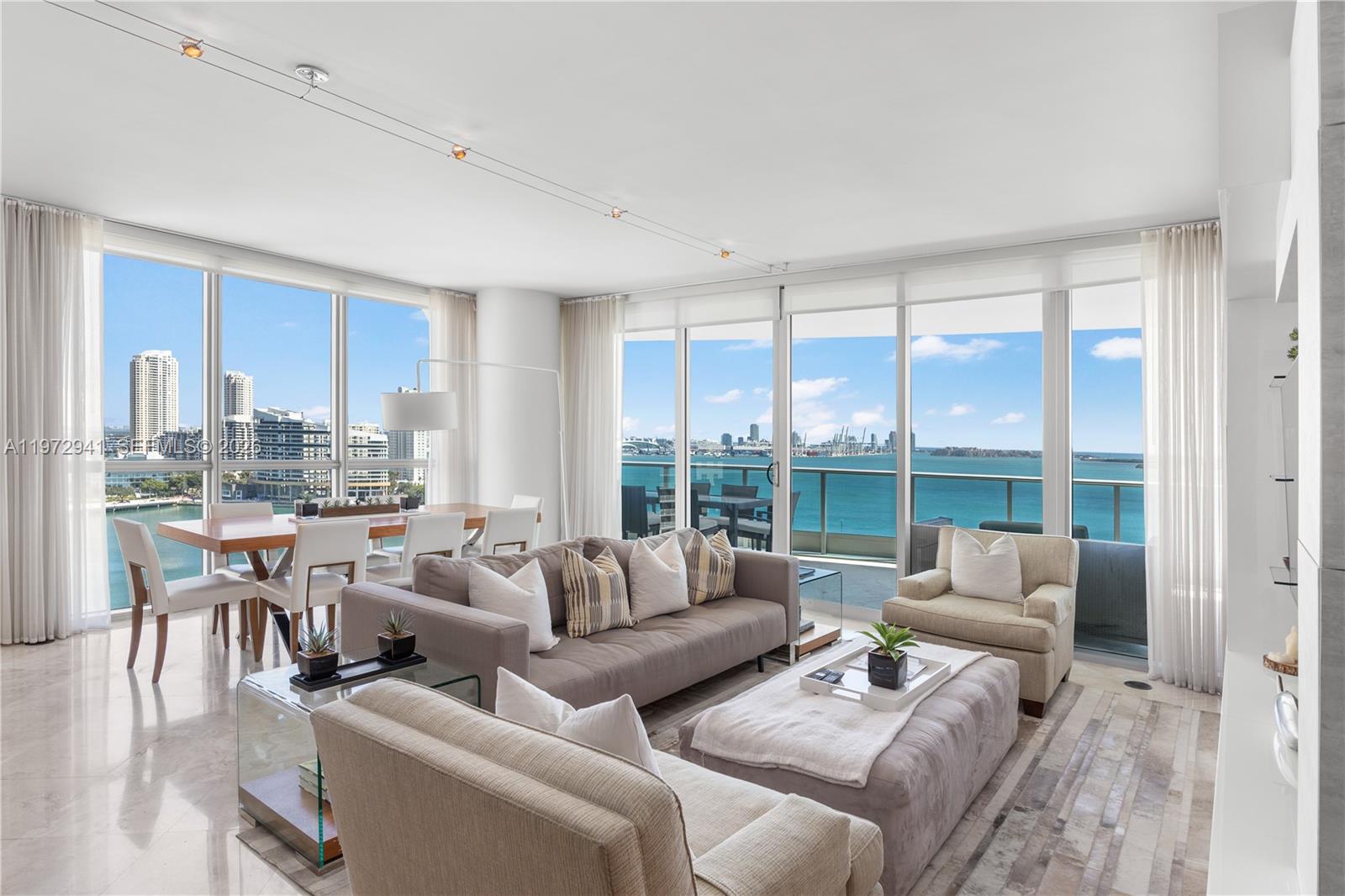 A spacious balcony features outdoor furniture, marble flooring, and panoramic views of the city skyline — 1331 Brickell Bay Dr # 1901, Miami FL 33131, MIAMI, FL