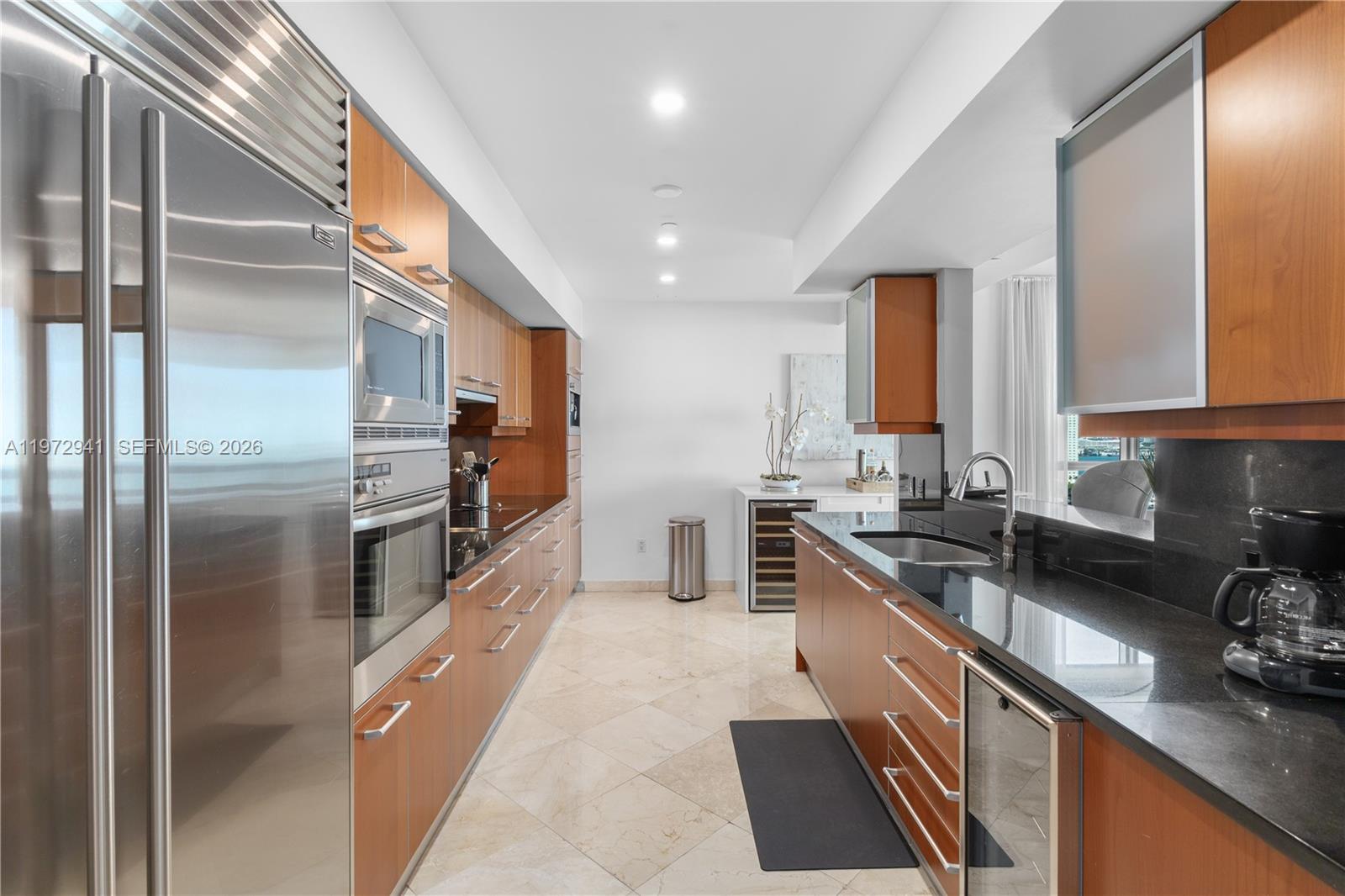 A modern living and dining area features floor-to-ceiling windows with expansive water and city views — 1331 Brickell Bay Dr # 1901, Miami FL 33131, MIAMI, FL