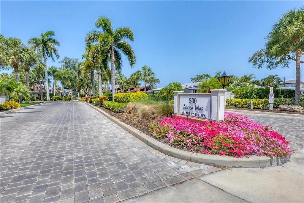 A paved driveway leads to a sign for Aldea Mar Village by the Sea — 500 PARK BOULEVARD S UNIT 24, VENICE, FL