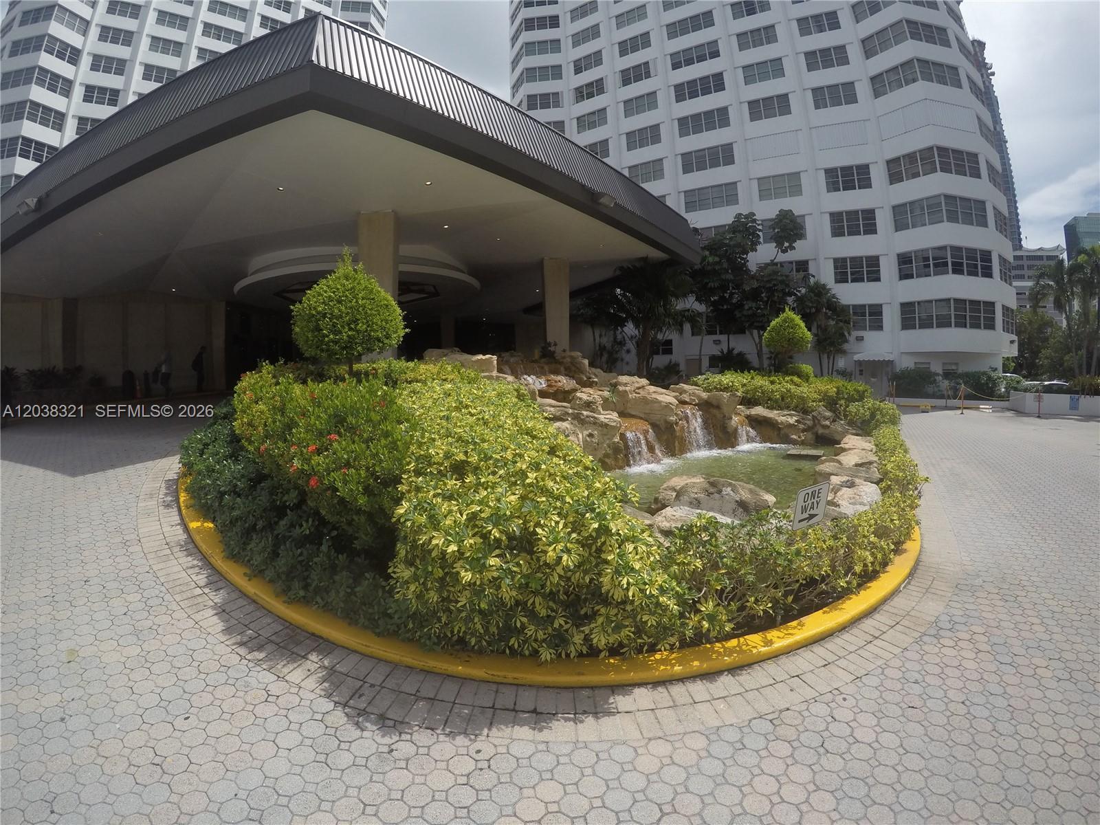 A circular driveway features a landscaped island with a rock waterfall and fountain — 801 Brickell Bay Dr # 364, Miami FL 33131, MIAMI, FL