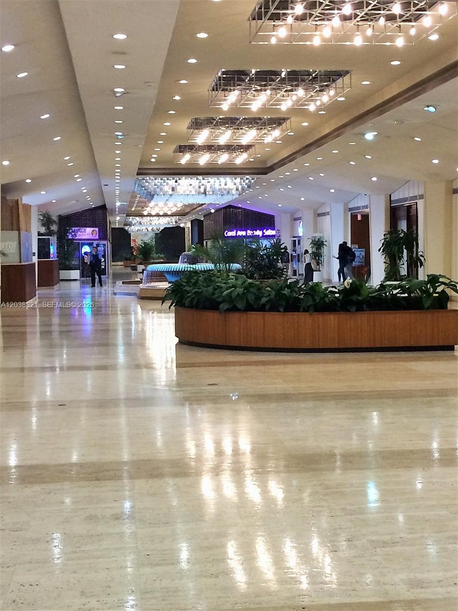 A spacious, polished-floor lobby features recessed lighting, hanging chandeliers, and a large central planter — 801 Brickell Bay Dr # 364, Miami FL 33131, MIAMI, FL
