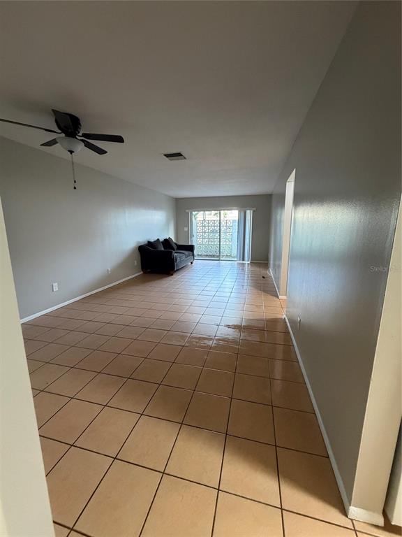 A long living room features light-colored tile flooring, gray walls, and a ceiling fan — 4607 W FIG STREET UNIT 108, TAMPA, FL