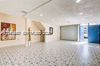 A spacious room features patterned tile flooring, recessed lighting, and a bright blue door — 12349 SW 132nd Ct # 9, Miami FL 33186, MIAMI, FL